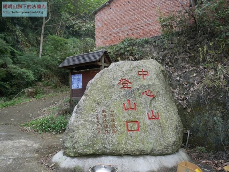 九份二山登山口,巨石刻有中心山登山口字樣,後方可見紅磚建築
